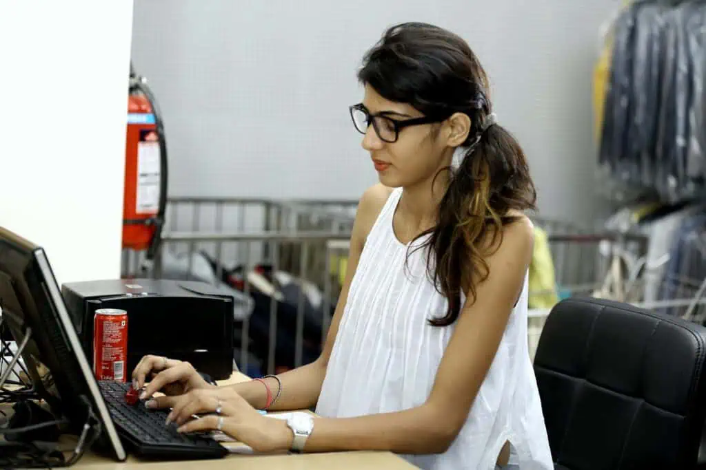 Woman working on a laptop, practicing the Law of Attraction for writers and creative success.