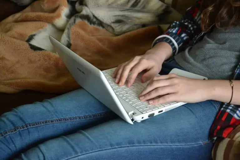 Woman using laptop to attract writing success with Law of Attraction principles.