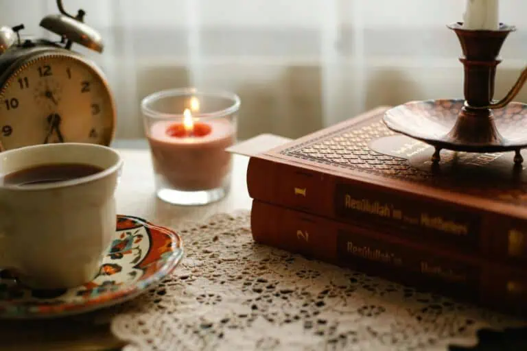 Cozy writing space with books, candle, and coffee for manifestation and the law of attraction.